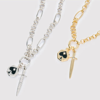 Layered gold and rhodium necklaces symbolizing courage and change