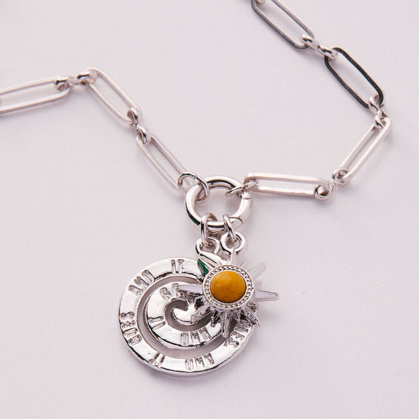 &LIVY Paperclip Intention Chain in finely finished silver close-up of paperclip link chain with round charm holder ring featuring celestial spinner charm and yellow gemstone sun charm