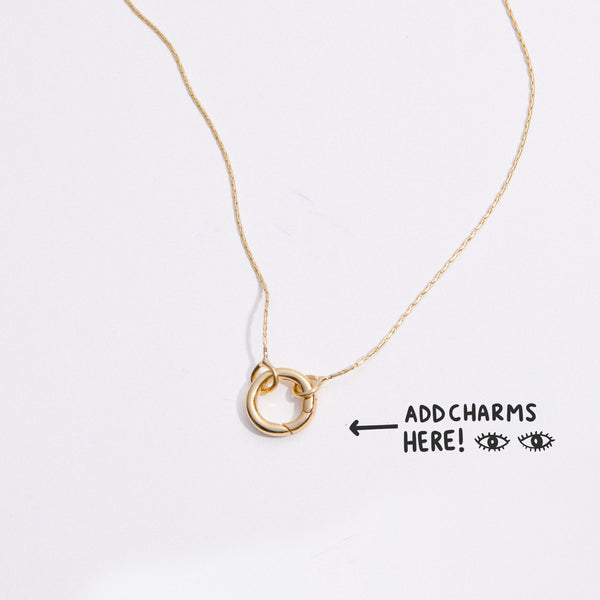 &LIVY Expandable Intention Chain Charm Necklace in gold showing interlocking ring clasp with text Add Charms Here and arrow pointing to charm holder on delicate gold chain