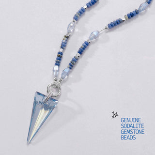 a flatlay of the gemstone limited edition necklace with crystal movable charm 