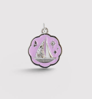 Pendant with sailboat design on a light purple background