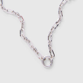 Silver chain necklace on a light gray background