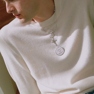 silver necklaces stacked on a man